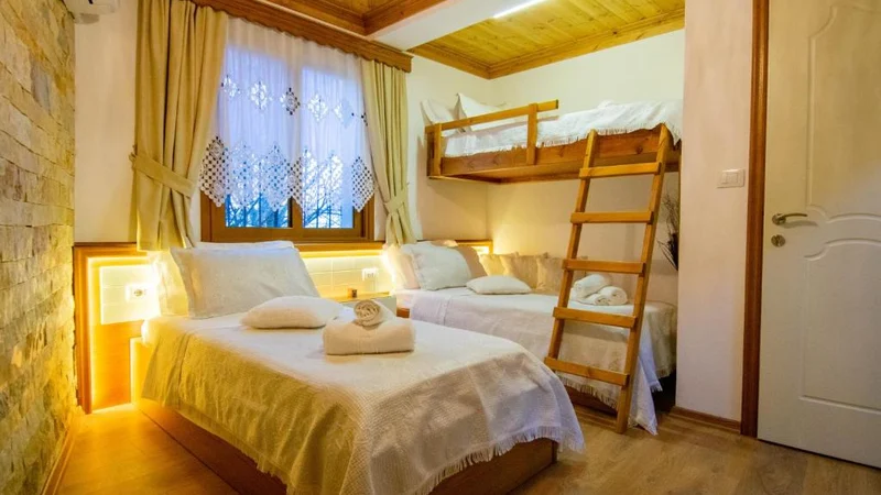 Pokój trzyosobowy Classic w Te Kalaja Rooms, z łóżkiem i drewnianym łóżkiem piętrowym przy oknie