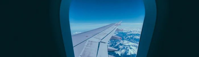 Ala de avión y montañas nevadas vistas desde la ventanilla